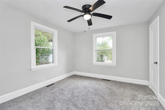 empty room featuring a ceiling fan, carpet flooring, visible vents, and baseboards