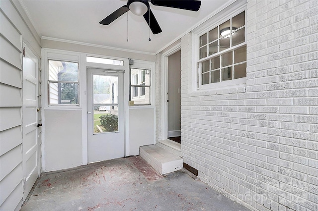 interior space featuring brick wall, ornamental molding, and a healthy amount of sunlight