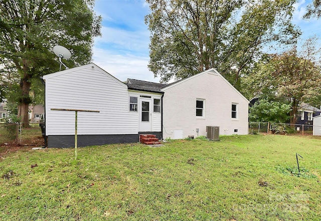 back of property featuring entry steps, a fenced backyard, a yard, central air condition unit, and brick siding