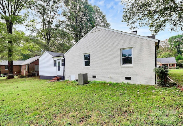 back of house featuring brick siding, a yard, central air condition unit, entry steps, and crawl space