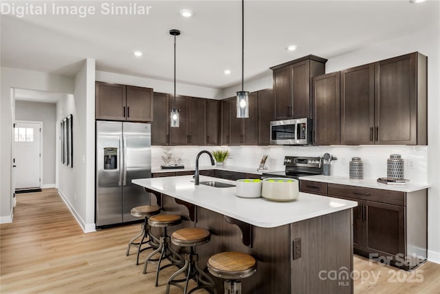 1626 Respect St NW, Concord, NC 28027 - kitchen with appliances with stainless steel finishes, dark brown cabinets, a breakfast bar area, light countertops, and recessed lighting