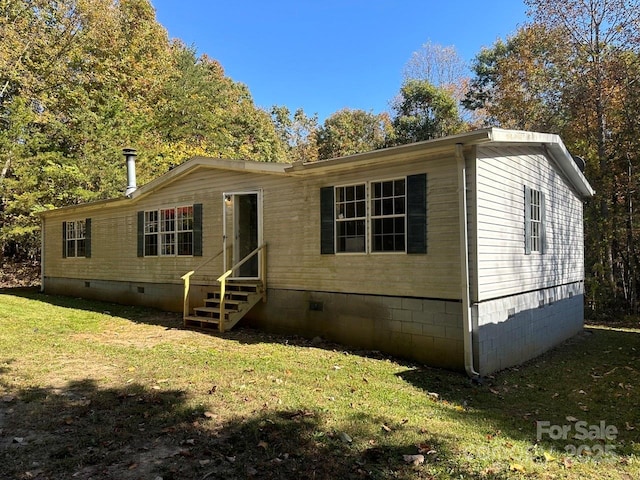 manufactured / mobile home featuring entry steps, a front lawn, and crawl space