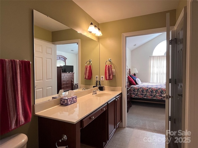 bathroom with toilet, ensuite bath, lofted ceiling, and vanity