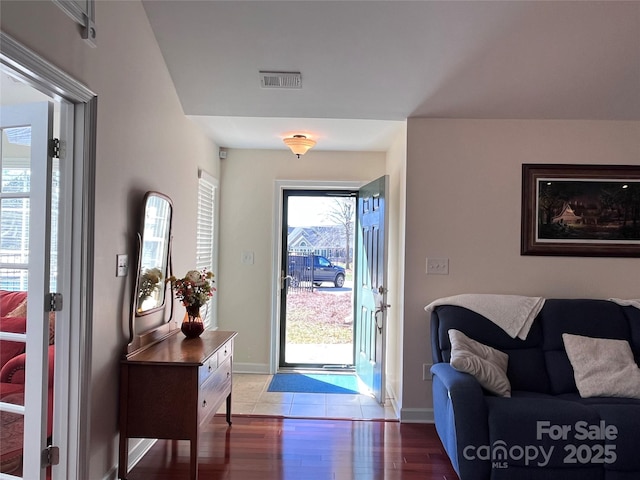 entryway with visible vents, baseboards, and wood finished floors