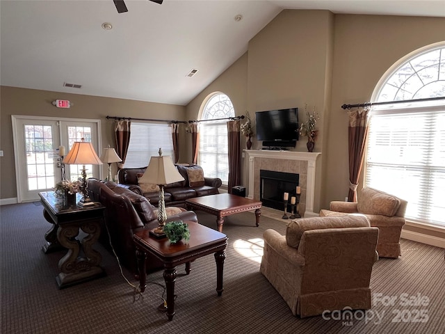 living room with a tiled fireplace, carpet flooring, and visible vents