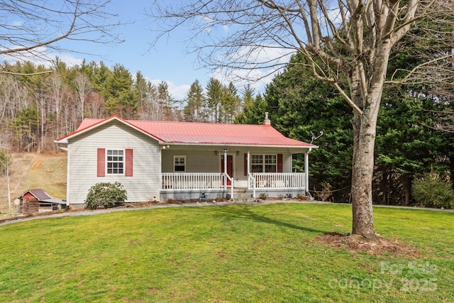 ranch-style house featuring covered porch, metal roof, a front lawn, and a chimney