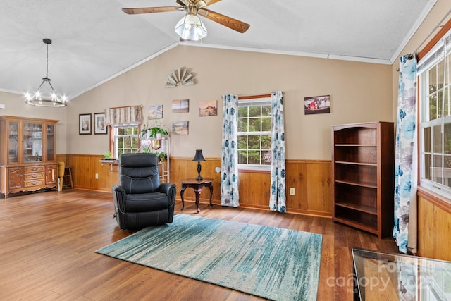 sitting room featuring a wainscoted wall, vaulted ceiling, and wood finished floors