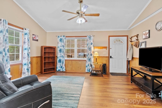 living room with wood walls, ceiling fan, wood finished floors, and wainscoting