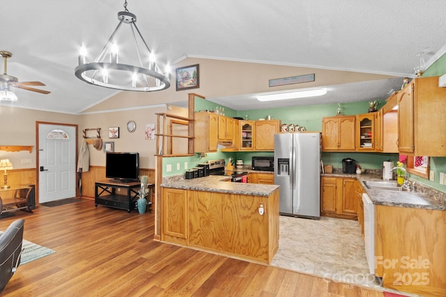 kitchen featuring glass insert cabinets, appliances with stainless steel finishes, a sink, and lofted ceiling