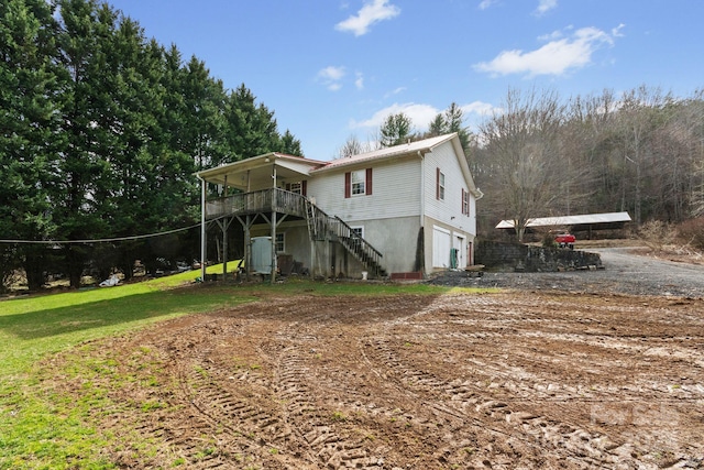 view of front of home with a deck, an attached garage, and stairs