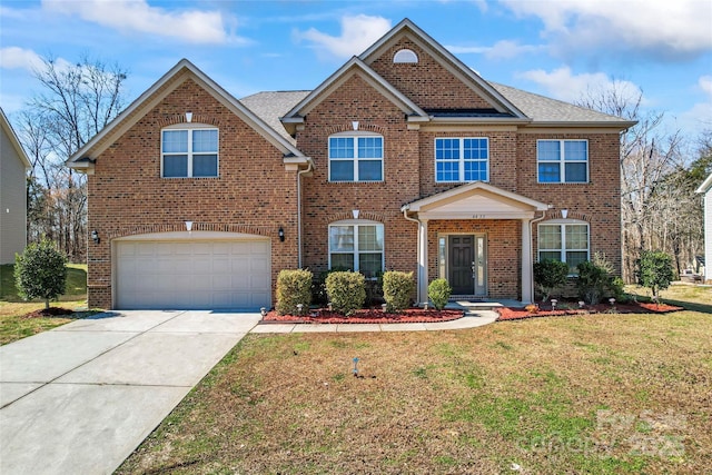 view of front of house featuring an attached garage, driveway, brick siding, and a front yard