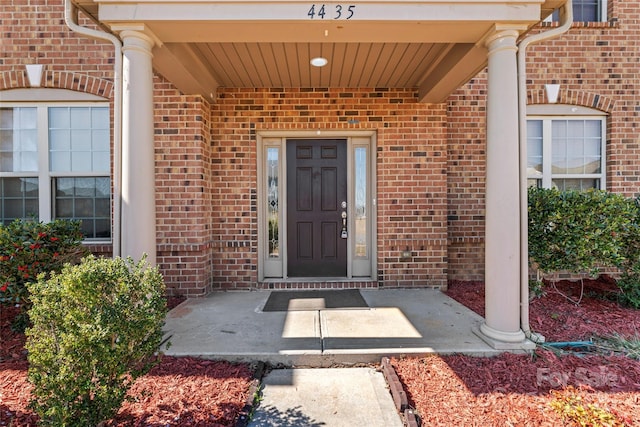 view of exterior entry with brick siding