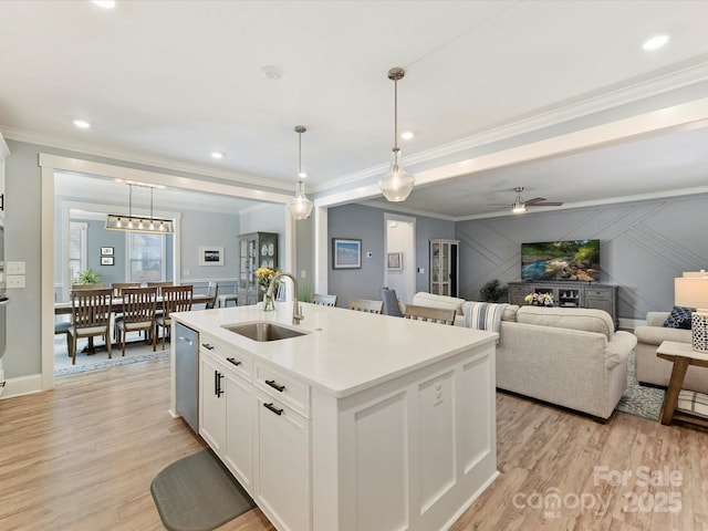 kitchen featuring light wood-type flooring, a sink, and crown molding