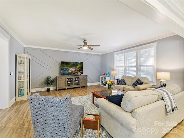 living area featuring ornamental molding, light wood-type flooring, and ceiling fan