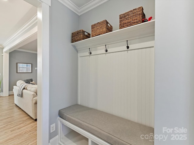 mudroom with crown molding, light wood-style flooring, and baseboards