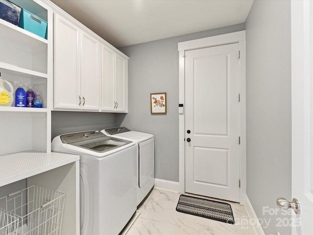 washroom with marble finish floor, cabinet space, independent washer and dryer, and baseboards