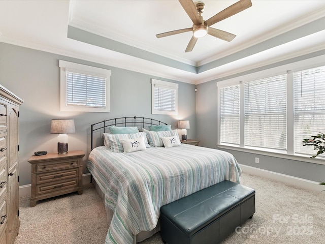 bedroom with ornamental molding, a raised ceiling, and baseboards