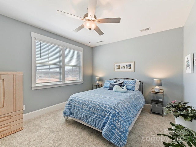 carpeted bedroom with a ceiling fan, visible vents, and baseboards