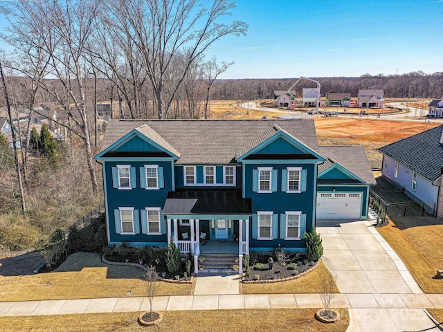 view of front of house featuring a garage, driveway, and a porch