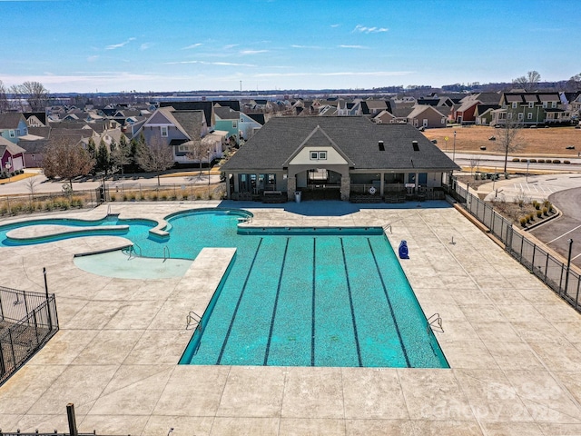 pool featuring a patio, fence, and a residential view