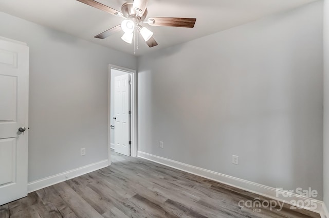 unfurnished room with light wood-type flooring, a ceiling fan, and baseboards