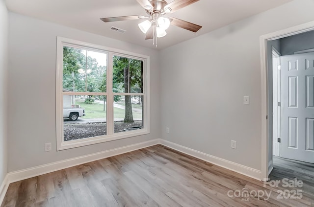 empty room with baseboards, visible vents, light wood-style flooring, and a ceiling fan