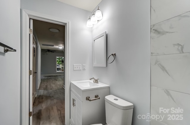 bathroom with visible vents, vanity, toilet, and wood finished floors