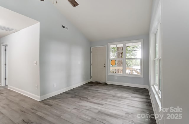 unfurnished room featuring high vaulted ceiling, light wood-type flooring, visible vents, and baseboards