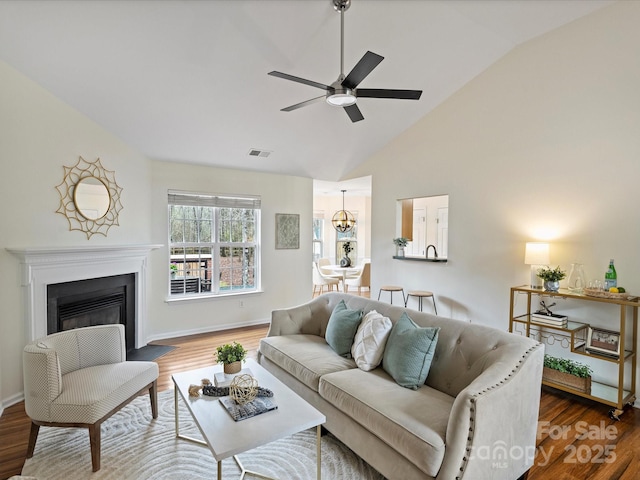 living room with visible vents, ceiling fan, baseboards, a fireplace with flush hearth, and wood finished floors