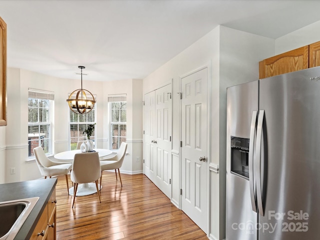 dining area featuring a wealth of natural light, a notable chandelier, and hardwood / wood-style flooring