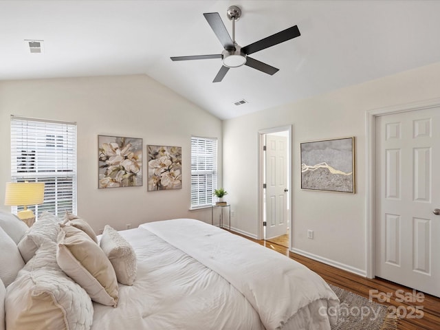 bedroom with visible vents, baseboards, lofted ceiling, and wood finished floors