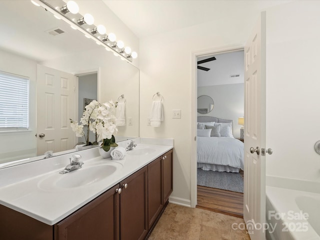 ensuite bathroom featuring visible vents, a washtub, ensuite bath, and a sink