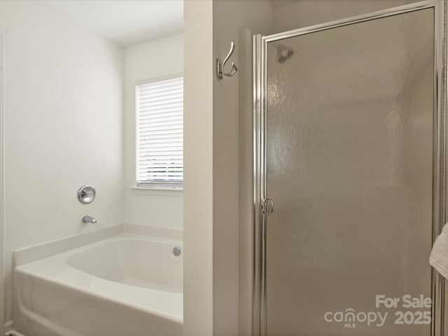 full bath featuring a bath and a shower stall