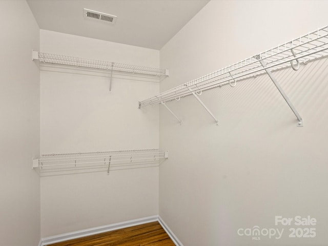 spacious closet featuring visible vents and wood finished floors