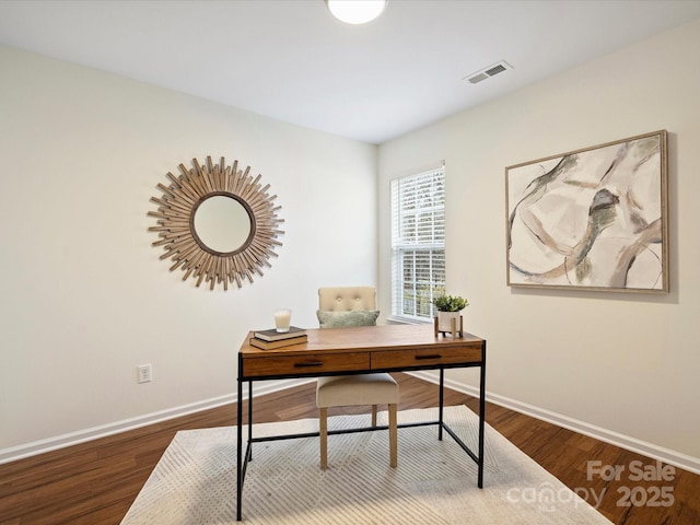 office space featuring wood finished floors, baseboards, and visible vents