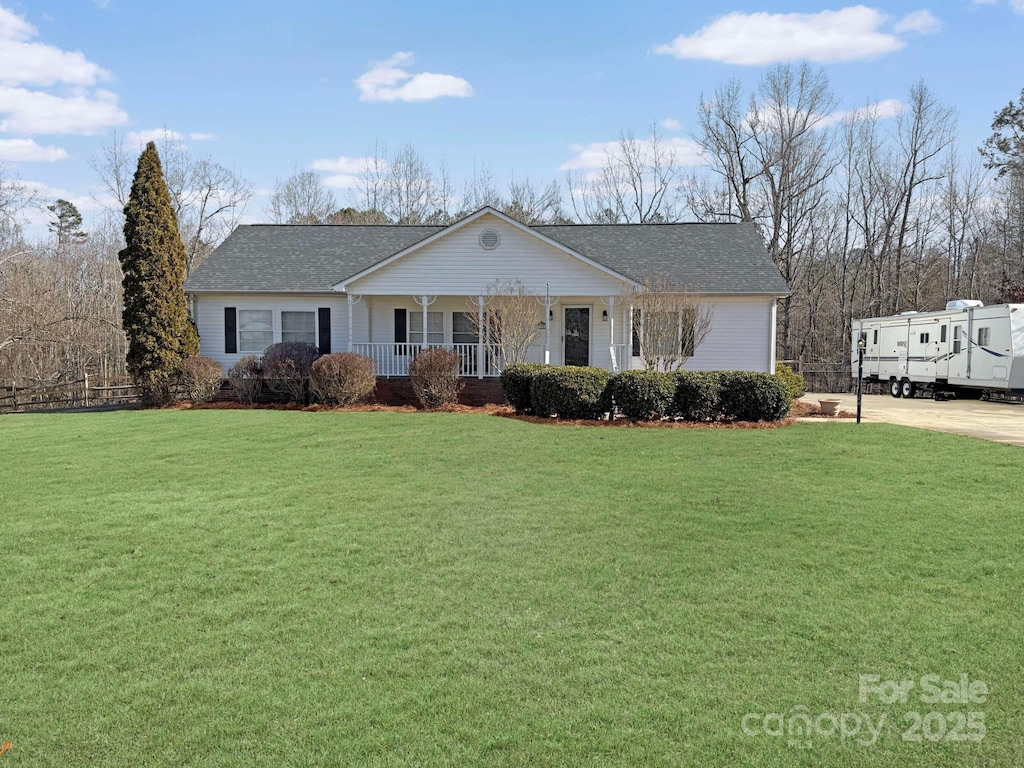 view of front of property with a porch, a shingled roof, and a front lawn