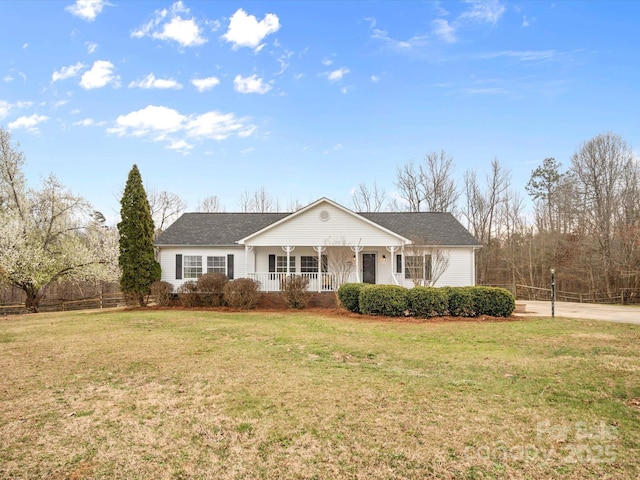 ranch-style house featuring a front lawn, fence, covered porch, concrete driveway, and a shingled roof