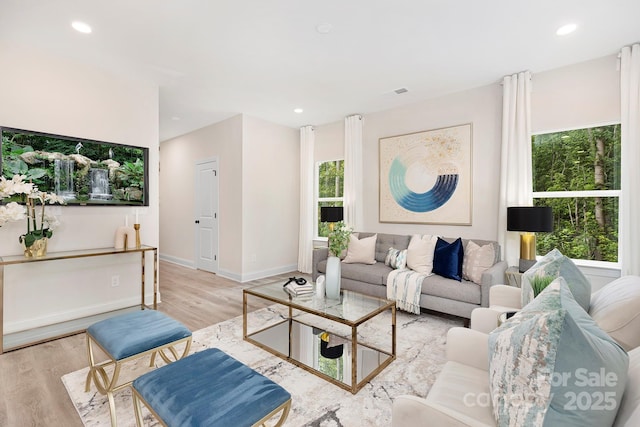 living area featuring recessed lighting, visible vents, light wood-style flooring, and baseboards