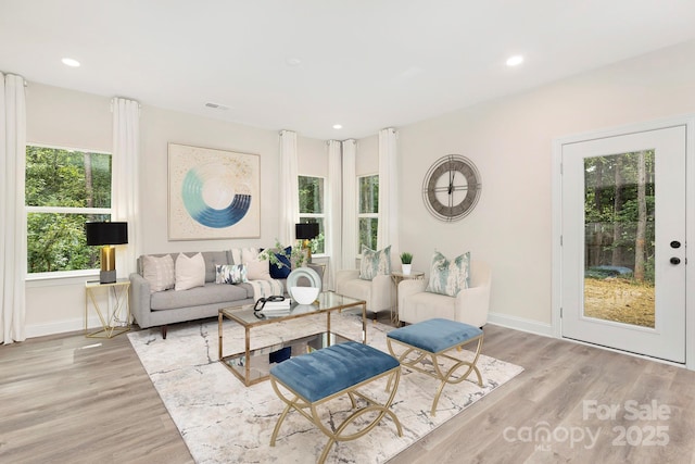 living room featuring light wood finished floors, baseboards, and recessed lighting