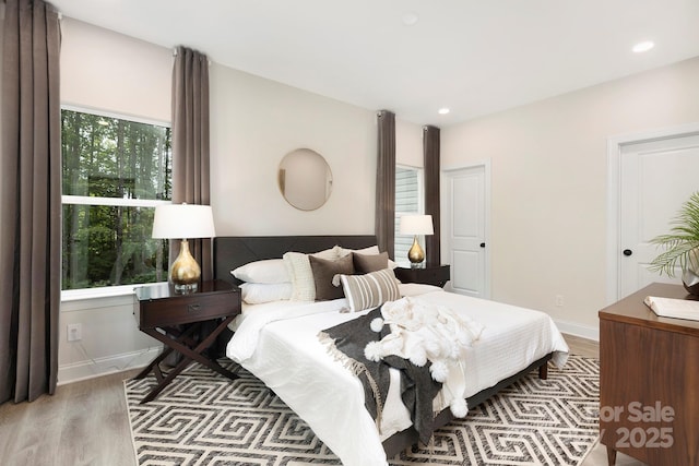 bedroom with baseboards, wood finished floors, and recessed lighting