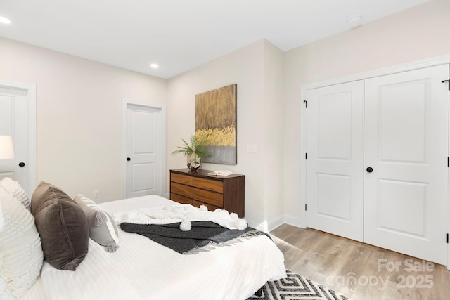 bedroom featuring light wood finished floors, baseboards, a closet, and recessed lighting