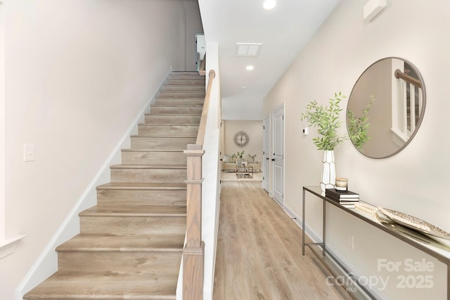 staircase with recessed lighting, baseboards, and wood finished floors