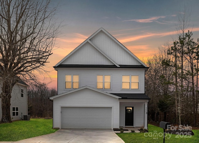 view of front of house featuring concrete driveway, a yard, and an attached garage