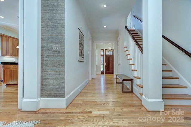 entrance foyer featuring light wood finished floors, ornamental molding, recessed lighting, and baseboards