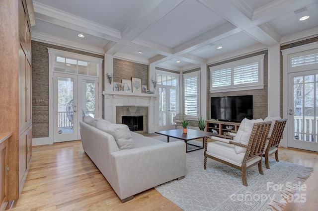 living room with beam ceiling, coffered ceiling, french doors, and a tile fireplace