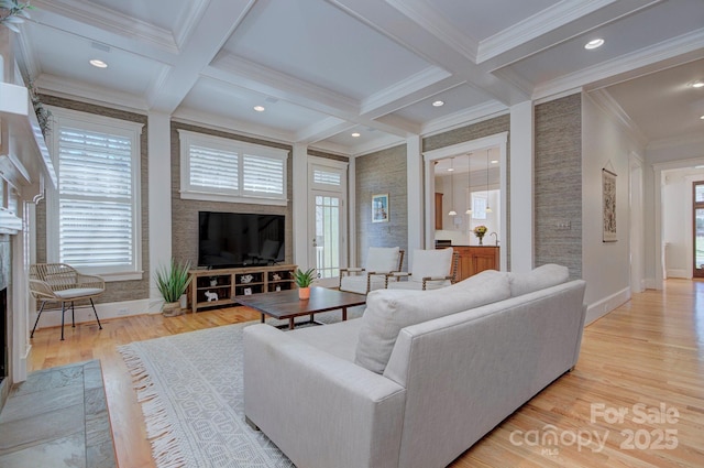 living area with light wood-style flooring, a fireplace, coffered ceiling, and beamed ceiling