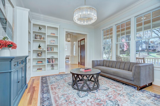 living room featuring light wood finished floors, a chandelier, a wealth of natural light, and crown molding