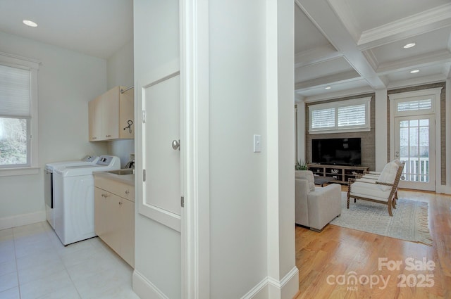 clothes washing area featuring recessed lighting, plenty of natural light, cabinet space, and baseboards