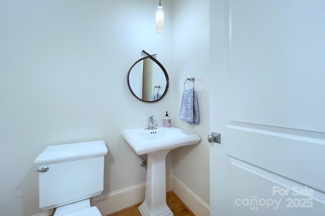 bathroom featuring toilet and baseboards