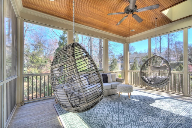 sunroom / solarium with a skylight, wooden ceiling, and ceiling fan